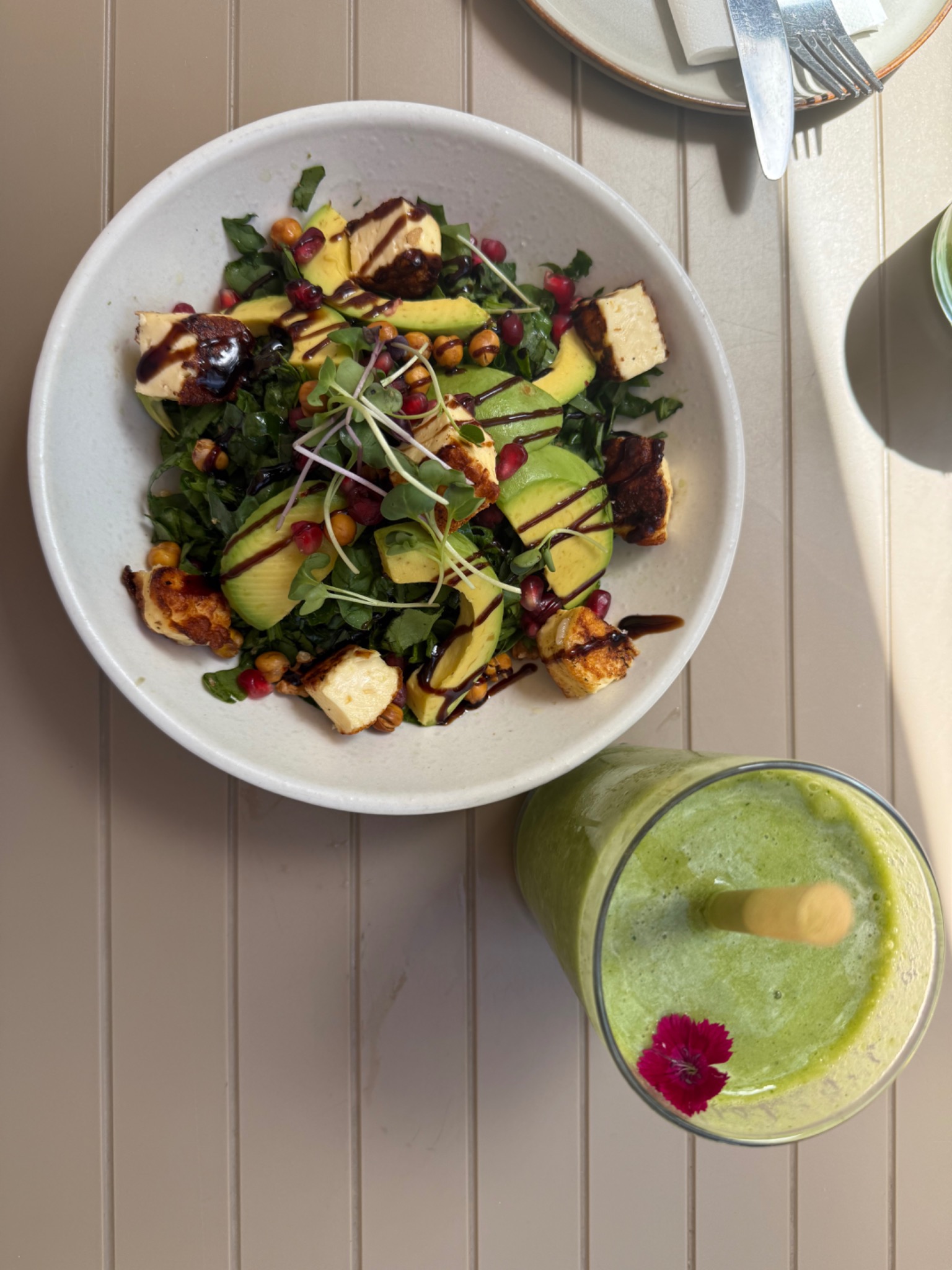 Colourful meal with avocado, greens and a green drink